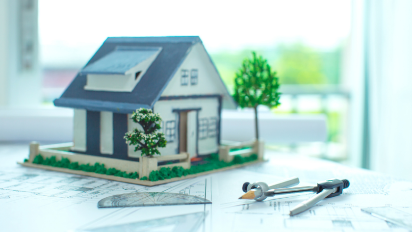 model of a house on top of construction plans